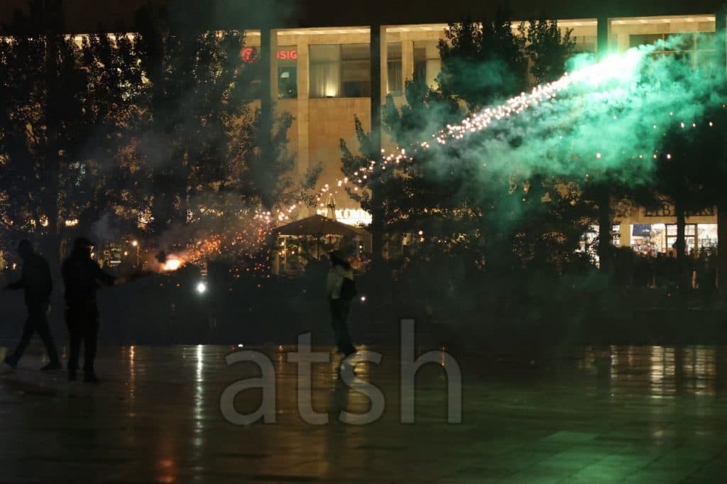 Protesters set off fireworks amid smoke in Skanderbeg Square at night