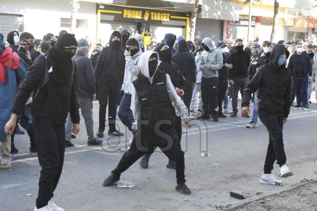 Të rinj me fytyra të mbuluara hedhin sende në rrugë gjatë protestës